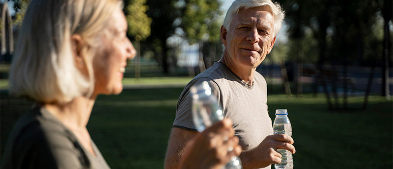 Side view older couple drinking water outdoors